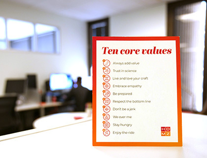 A photo of an office featuring a card showing HDMZ's ten Core Values 