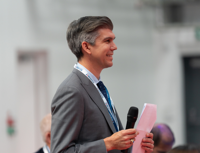 Man smiling and holding a piece of paper