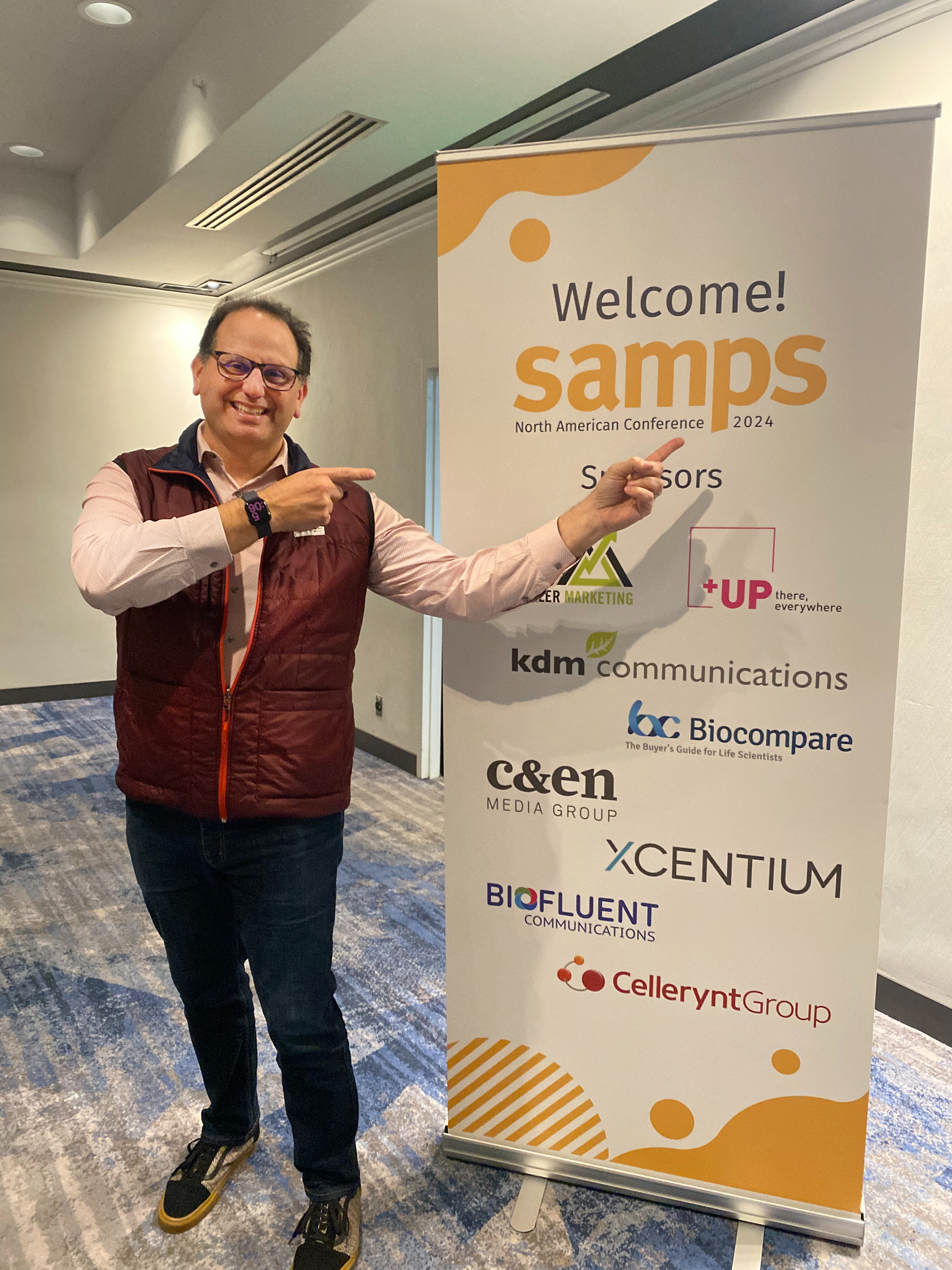 person standing by a sign at a conference