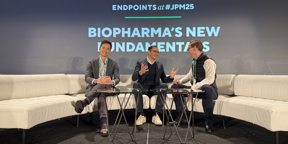 Three men on stage sitting on a white couch at JPM Endpoints 2025